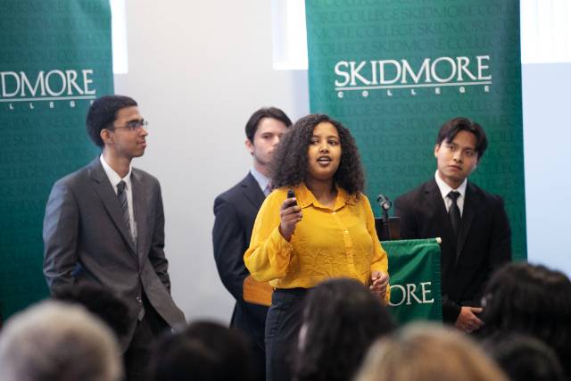 Azizul Hakim ’26 (left), Fiker Tadesse ’26 (center), Jacob Kriss ’25 (behind Tadesse), and Casey Rueda ’24 (right), who placed third, present their business plan.