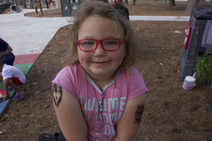 Children at Westside Park receive tattoos from Sophia Hubbard, 10, April 10, 2024. (Nicole Beltran/WUFT News)