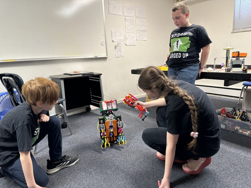 Charged Up! team members as they demonstrate and work on their robot "Gerald."