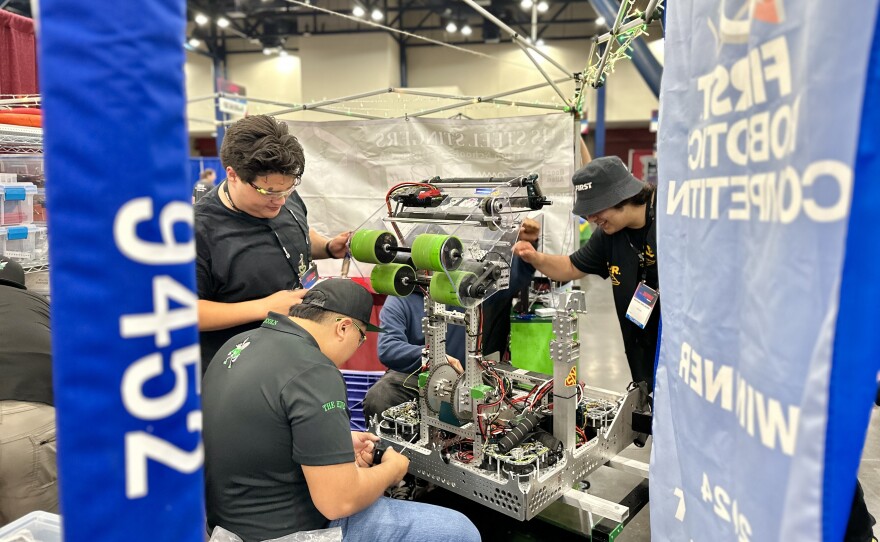 Team members of the Lincoln High School Steel Stingers make adjustments to their robot, Wednesday, in preparation for qualifying rounds at the George R. Brown Convention Center in Houston, Texas, April 17, 2024