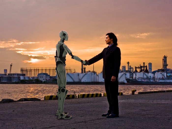 A humanoid robot shaking a person's hand.