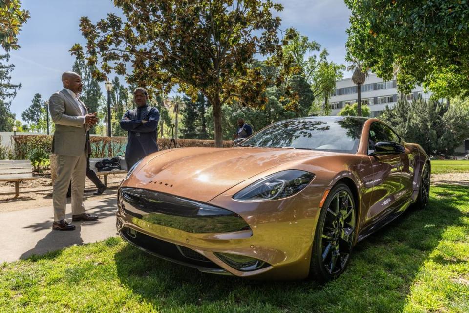 Karma CEO Marques McCammon talks at the Capitol on Wednesday to Assemblyman Corey Jackson, D-Riverside, about Karma Revero, a range-extended luxury electric vehicle manufactured in the legislator’s district.