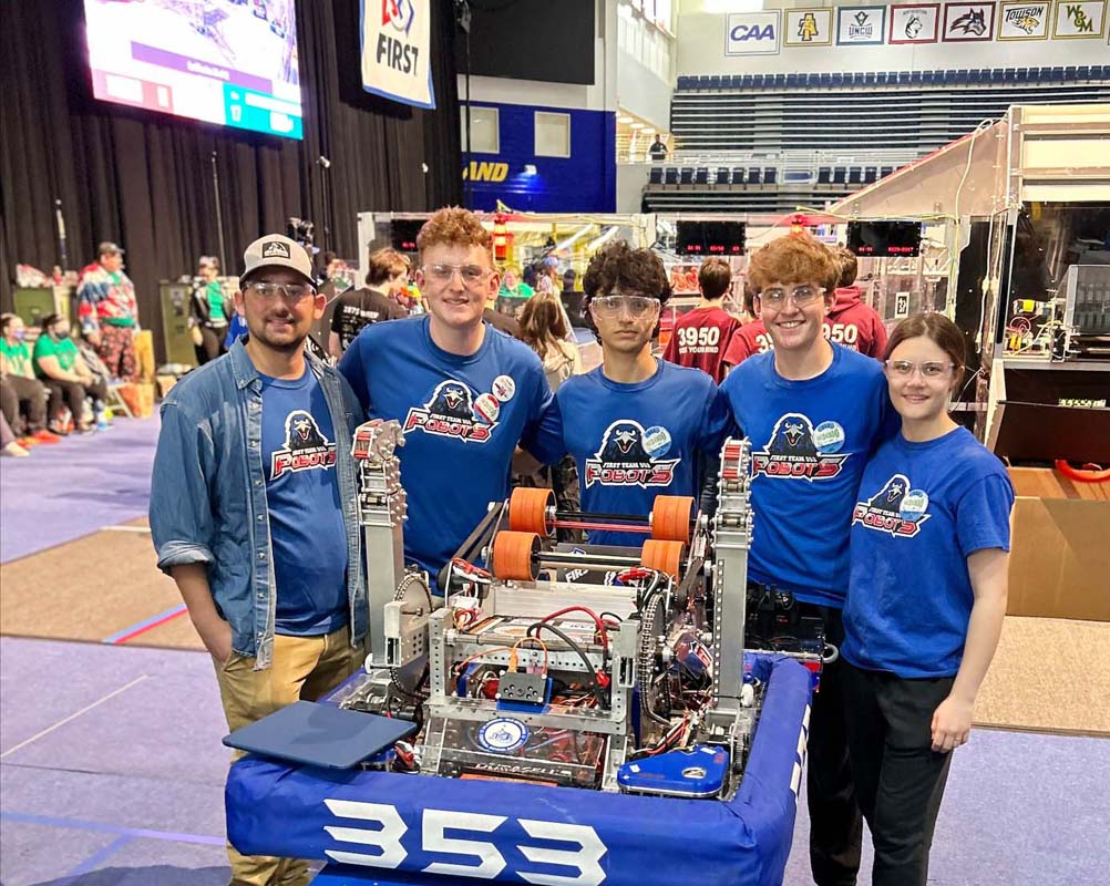 teens posing with robot