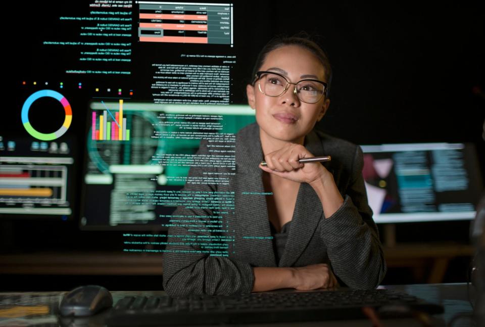 A person studying a see-through display of various charts and graphs.