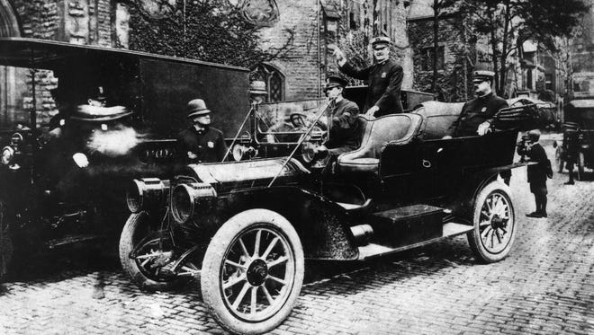 This may be the city's first police car. It appears to be a Packard from around 1909 or 1910, purchased for the department by Frank Croul. The officer standing in the backseat is identified as Burton Girardin, grandfather of Ray Girardin, who was police commissioner in the 1960s.