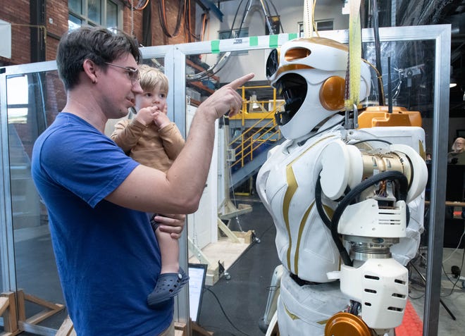 Research scientist Geoff Clark shows his son Callen Clark, 2, a robot in the Robotics Lab during the IHMC open house in Pensacola on Thursday, April 11, 2024.