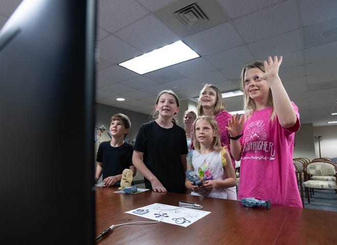 From right, Lilly Trenka, 10, Maddie Trenka, 13, Tammy Trenka, 7, Kim Trenka, Laila Bobbitt, 11, and Grayson Bobbitt, 7, take turns using hand motions to control a computer during the IHMC open house in Pensacola on Thursday, April 11, 2024.