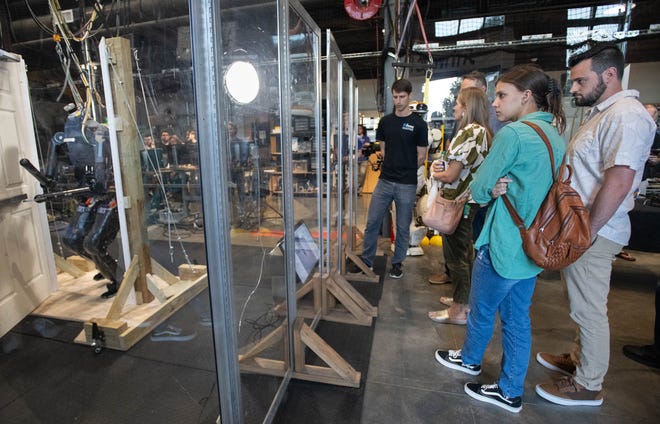 Layton Davis, right, and Brooklynne Luedtke, of Milton, watch a robot named Nadia open and walk through a door in the Robotics Lab during the IHMC open house in Pensacola on Thursday, April 11, 2024.