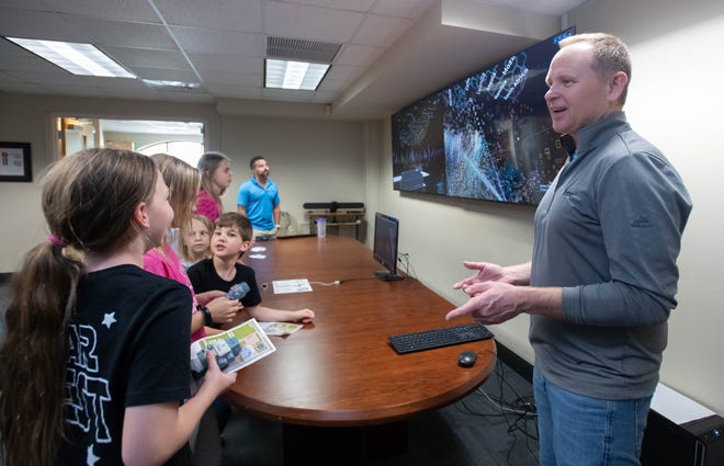 Researcher Larry Bunch, right, instructs the Trenka and Bobbitt children how to use hand motions to control a computer during the IHMC open house in Pensacola on Thursday, April 11, 2024.