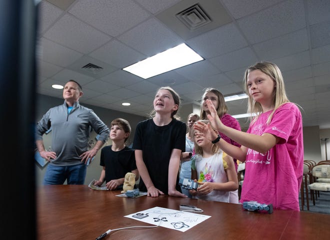 From right, Lilly Trenka, 10, Maddie Trenka, 13, Tammy Trenka, 7, Kim Trenka, Laila Bobbitt, 11, nd Grayson Bobbitt, 7, and researcher Larry Bunch take turns using hand motions to control a computer during the IHMC open house in Pensacola on Thursday, April 11, 2024.