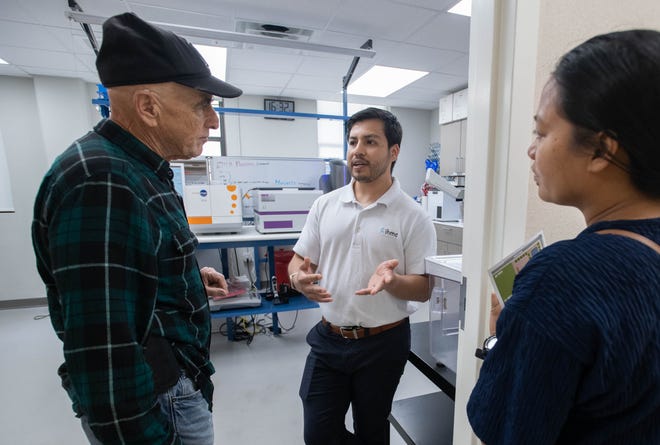 Research associate Benny Segovia, center, gives a tour of his lab to Allen and Richel Moretksy, of Gulf Breeze, during the IHMC open house in Pensacola on Thursday, April 11, 2024.