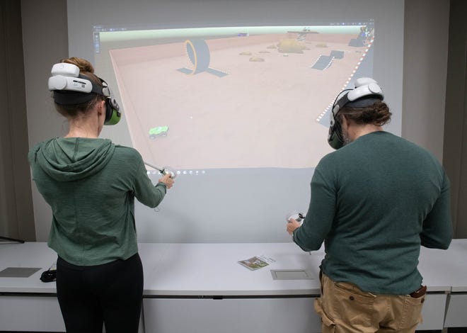 Teresa Hess, left, and Patrick Willi try virtual reality equipment during the IHMC open house in Pensacola on Thursday, April 11, 2024.