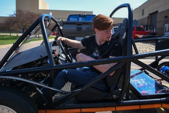 Harrisburg senior Kendrick Droppers, 18 reverses the electric car into the garage on Wednesday, April 24, 2024, at Tiger Stripes Garage in Harrisburg.