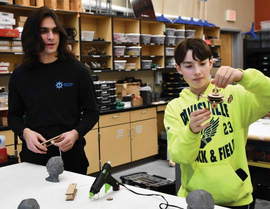 Zach DiBiase, left, oversees a STEM workshop last week in the makerspace at North Kingstown High School. Leading the five-week program for middleschool students was his senior project. As a member of the GONK Squad, which qualified for next week’s world robotics championship in Houston, he was tasked with outreach. PHOTO BY ANDREA VON HOHENLEITEN