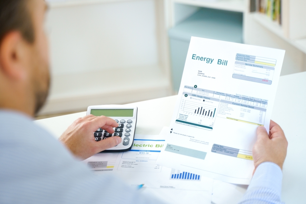 man looking at energy bill with calculator