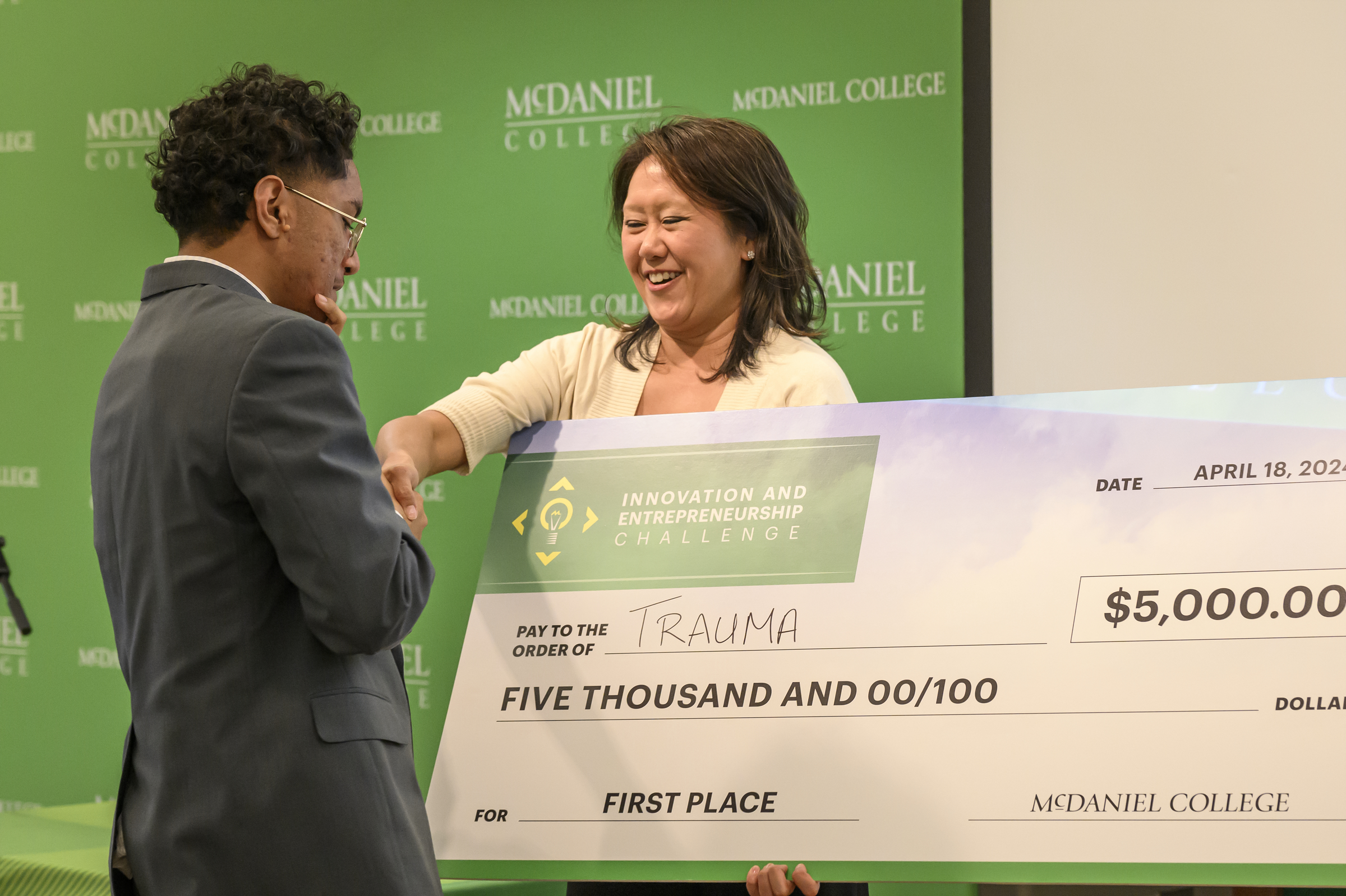 Jennifer Yang, Entrepreneur-in-Residence, presents Josiah Yung with a check for winning the Innovation and Entrepreneurship Challenge at McDaniel College. (Thomas Walker/Freelance)