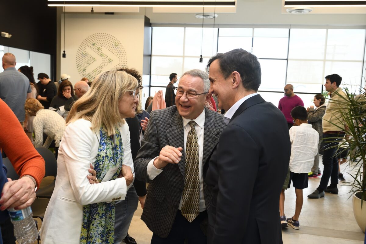 Caroline and Frank LaPere and Ronald J. Daniels speak inside of The Pava Center's white and black interior walls.