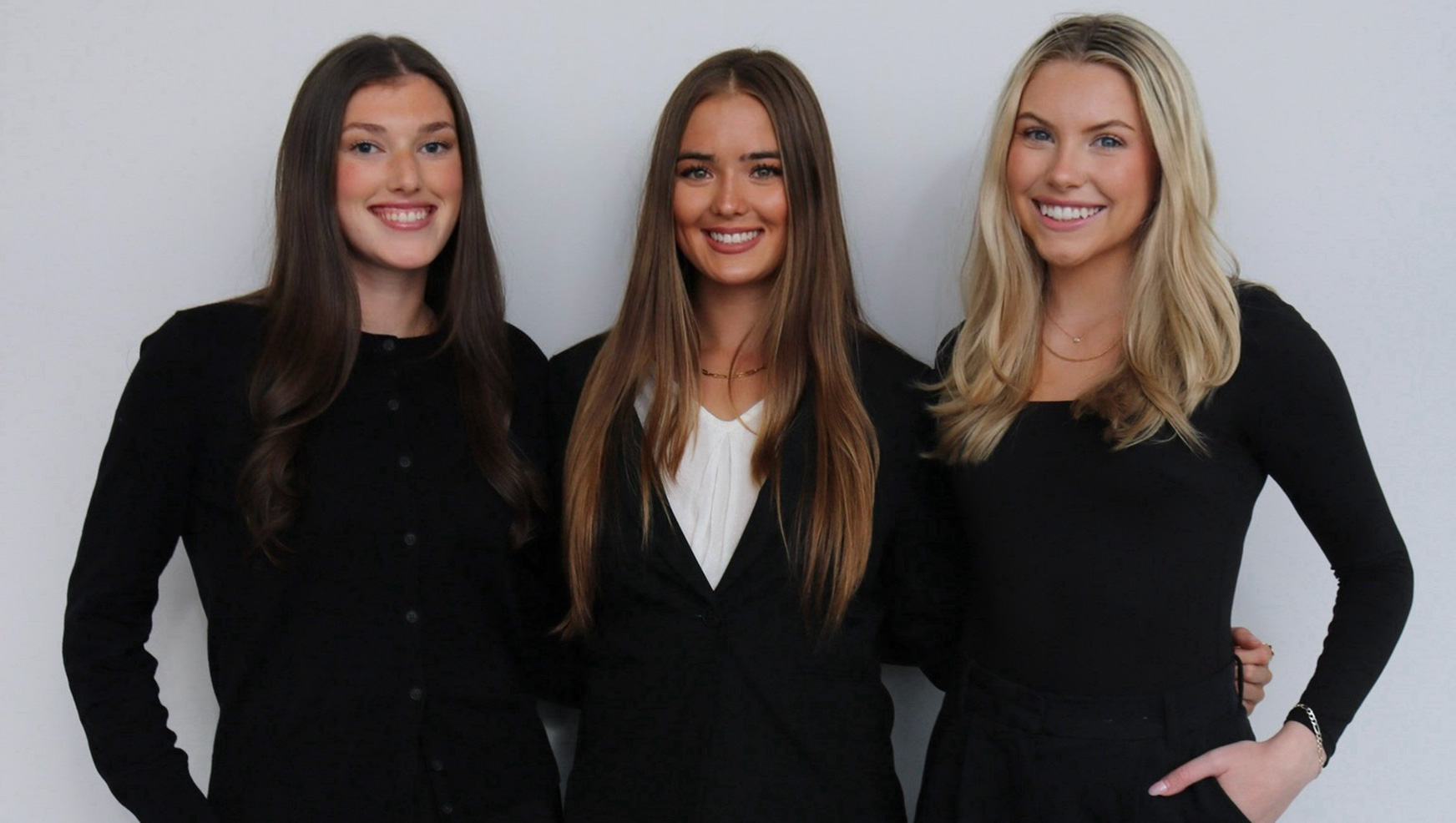 Three students standing together in a photo.