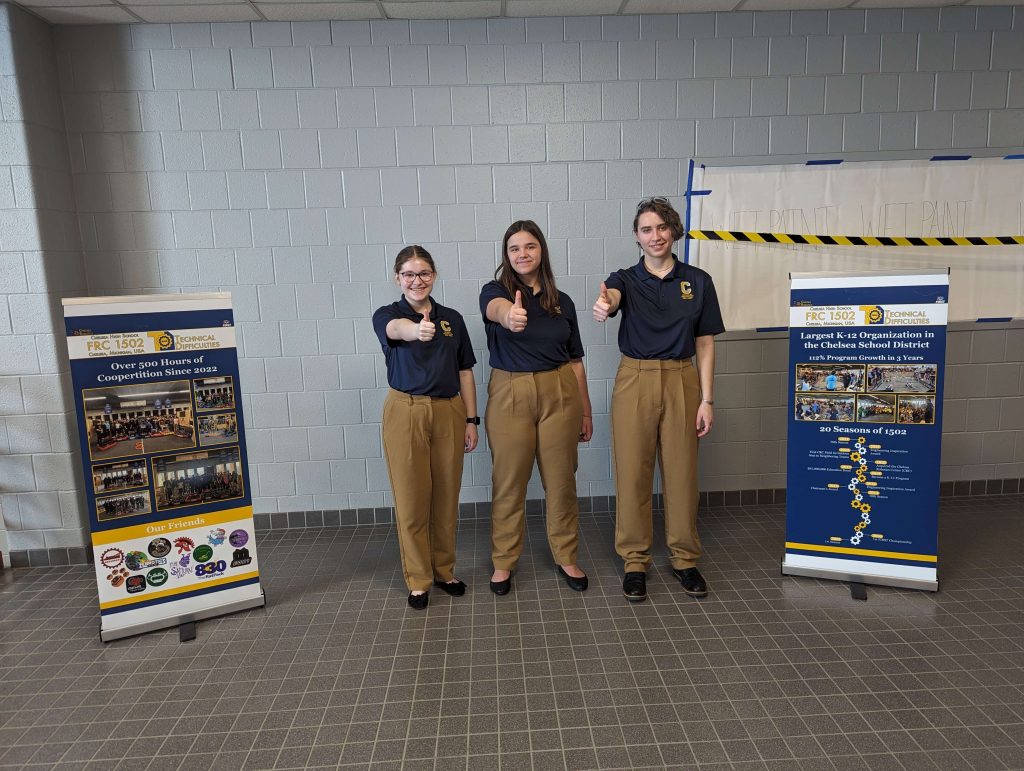 three high school students in school giving a thumbs up