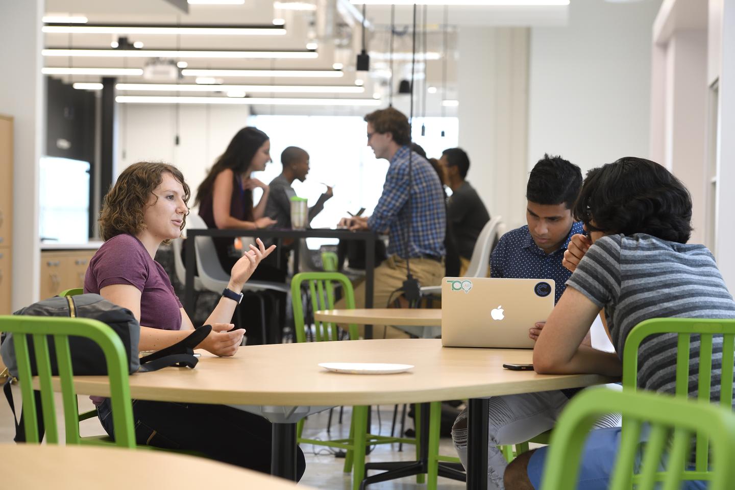 Pava LaPere talks to two classmates while they sit at a table in the Johns Hopkins Fastforward U building.