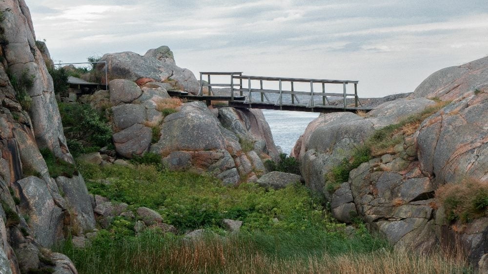 Distant view of a small wooden bridge connecting two cliffs in Sweden in piece about AI search generative experience.