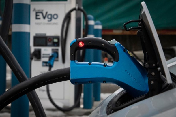 A blue electric car charger at a charging station.