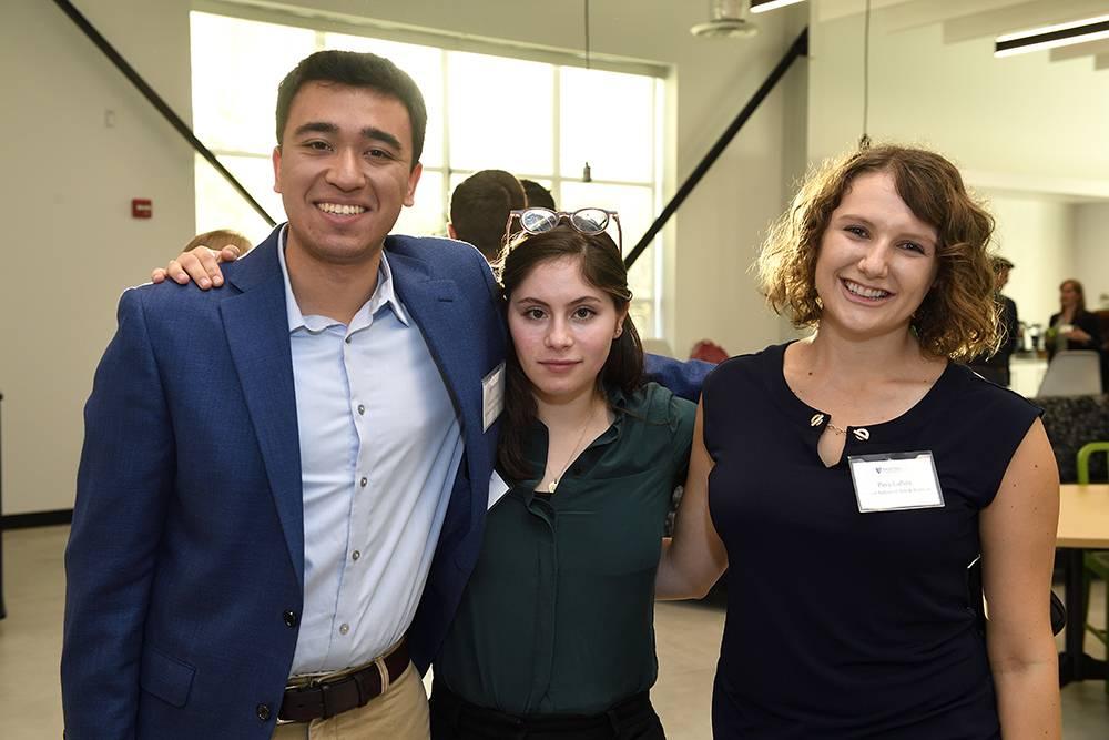 Anthony Garay, Brooke Stephanian, and Pava LaPere smile for the camera with their arms around each other.