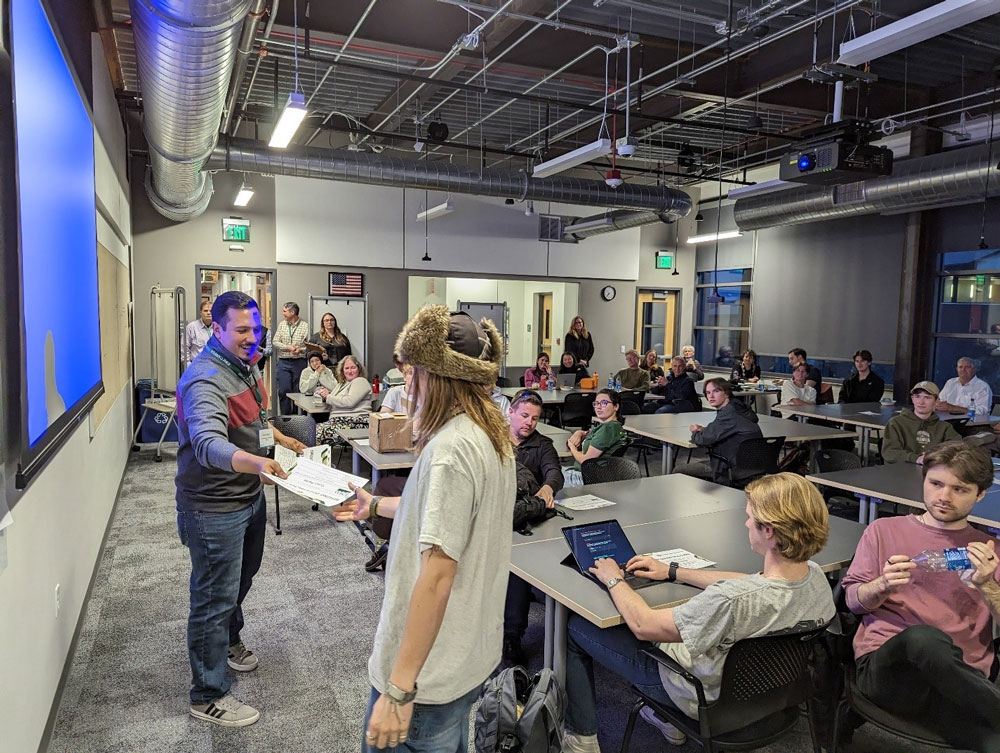 USDA Deputy Chief Data Officer Fredy Diaz presenting a certificate to one of the hackathon winners