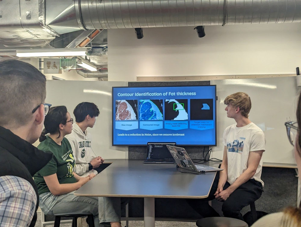 Three hackathon participants presenting their work to the USDA and Colorado State University judges