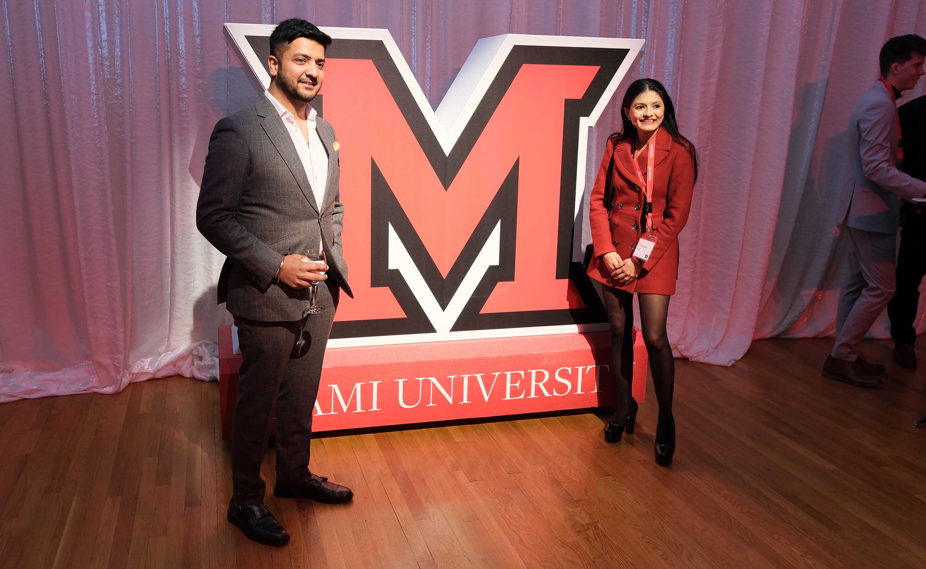 Couple pose with "M" statue