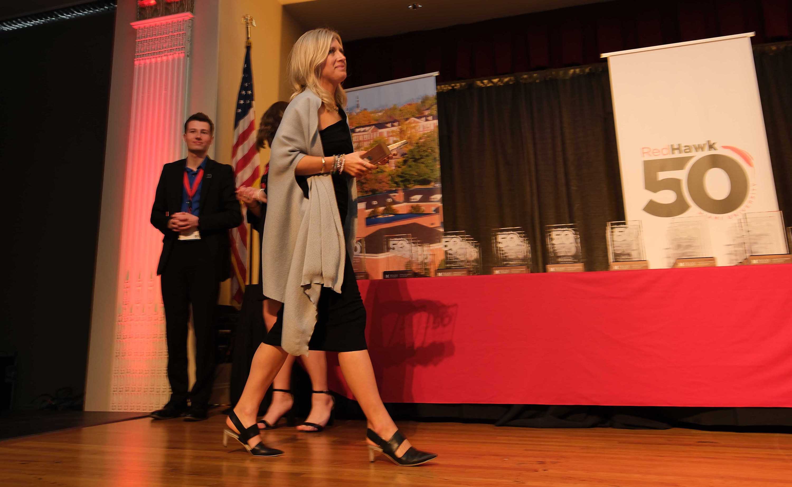 Honoree walks along stage with award