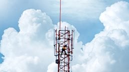 Telecommunication tower with backdrop of blue sky and white clouds