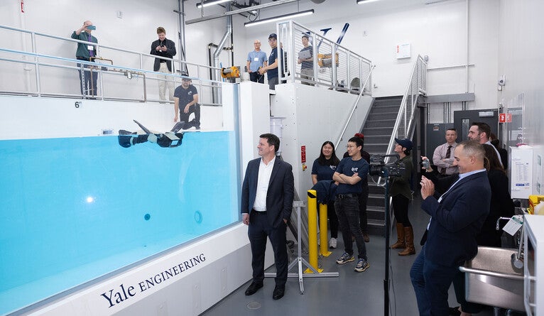 A group of people standing next to 20,000 gallon tech tank.