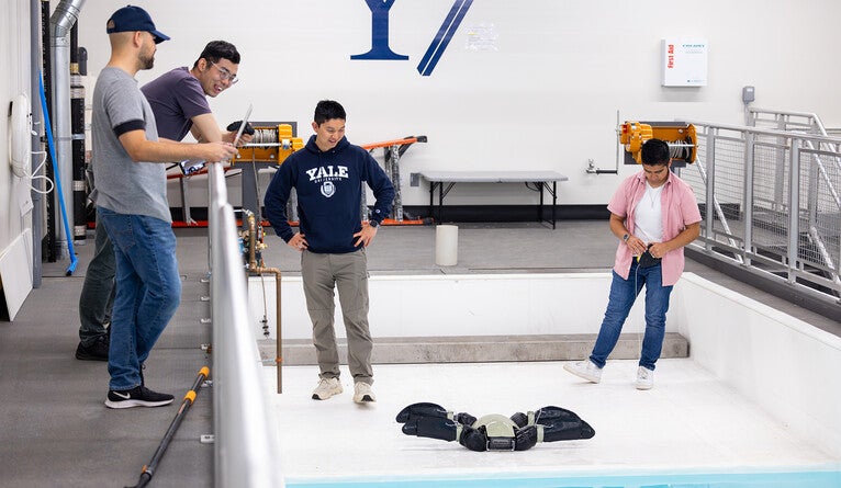 Students with a robotic turtle in a large lab space.