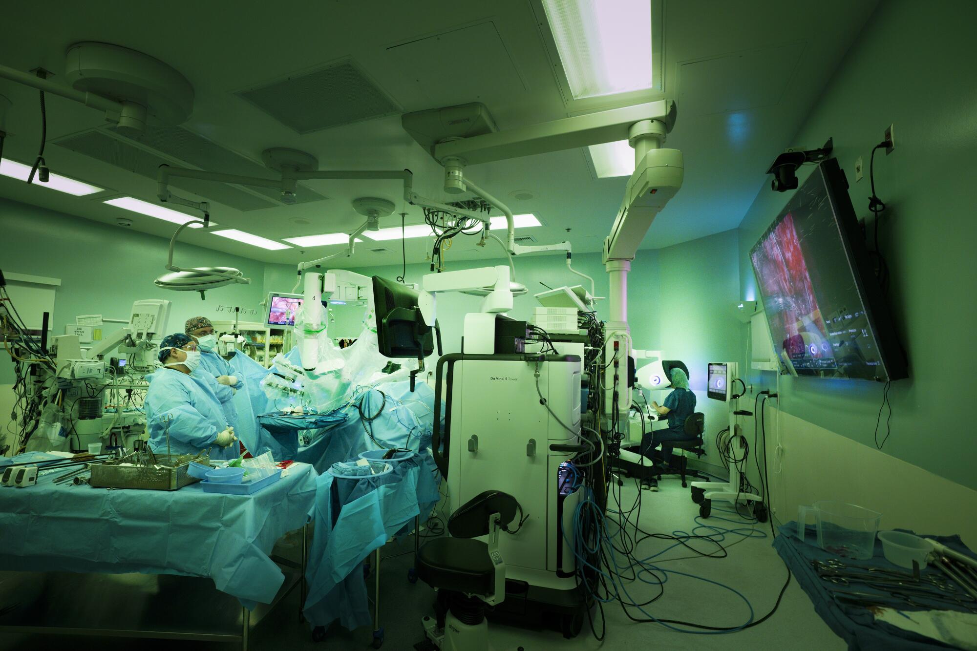 Pamela Lee, MD, right, works from the surgeon console where she controls the robotic surgical procedure on her patient.