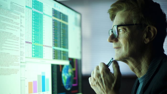 Calm man looking at a computer screen analyzing investments.