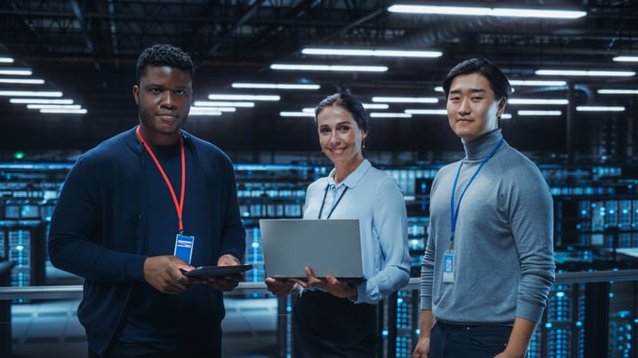 A team of engineers stands in a data center.