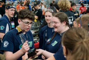 Cameron Souza shows the team trophy to Laura Hoag and Maddie Gomes. (U.S. Navy photo by Timothy Sieben)