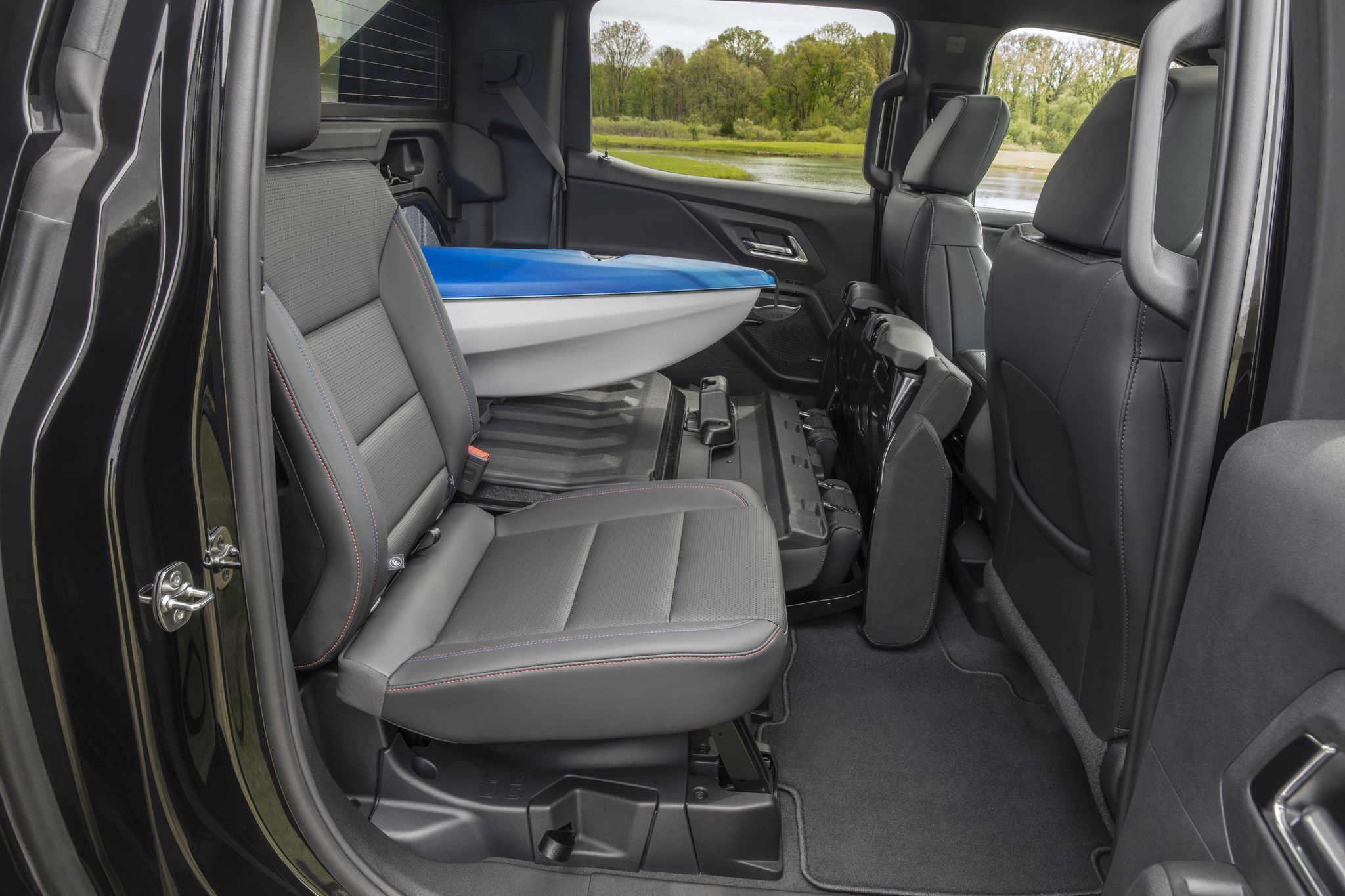 a view showing the 2024 silverado ev rst multi flex midgate from the second row, holding a kayak