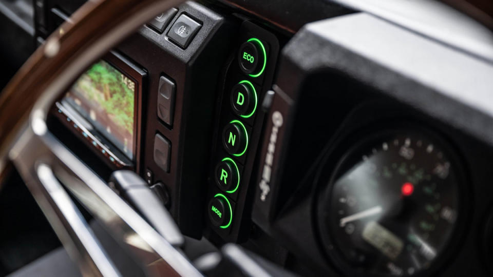 The center console's panel of push-buttons for Drive, Reverse, Park, and Eco mode inside Bedeo's 2005 Land Rover Defender 110 restomod.