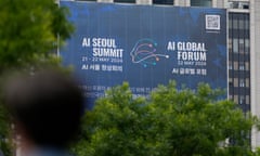 A man passes by alarge banner for the AI Seoul summit in Seoul, South Korea, on Monday.