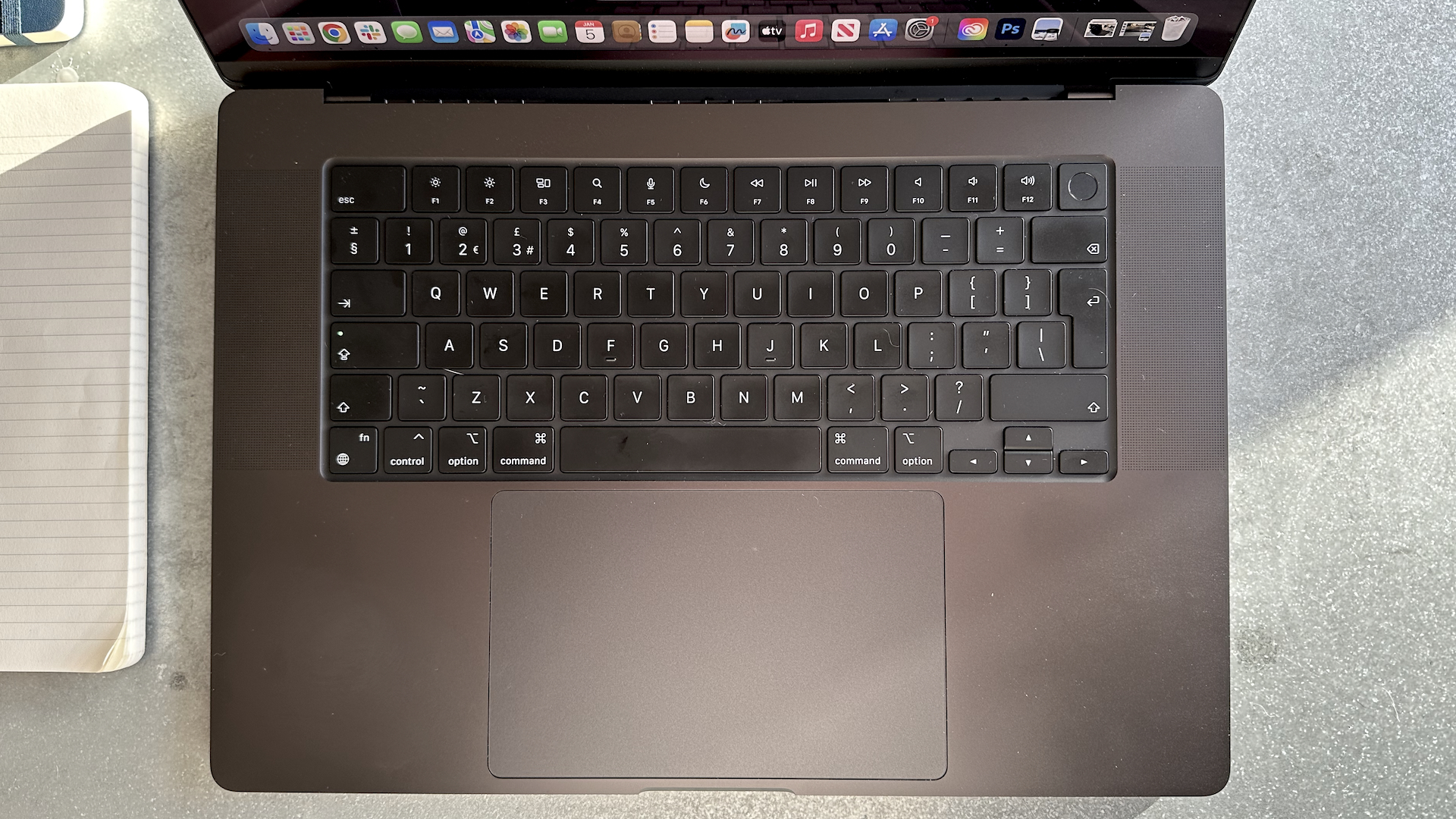 A Space Black Apple MacBook Pro M3 sitting on a grey/blue table