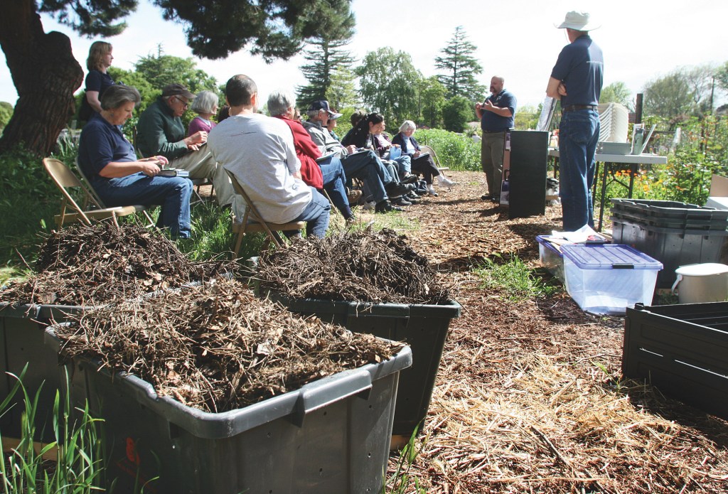 With compost debris in the foreground, Brian Debasitis, center, and Russ Behel, right lead the home composting class at the Palo Alto Community Garden on April 17, 2010.  Photo by Veronica Weber.