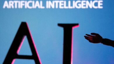 FILE PHOTO: Illustration shows AI (Artificial Intelligence) letters and robot hand miniature – Arizona Daily Sun