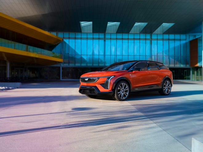 A front 3/4 view of the 2025 Cadillac Optiq compact SUV in Monarch Orange.