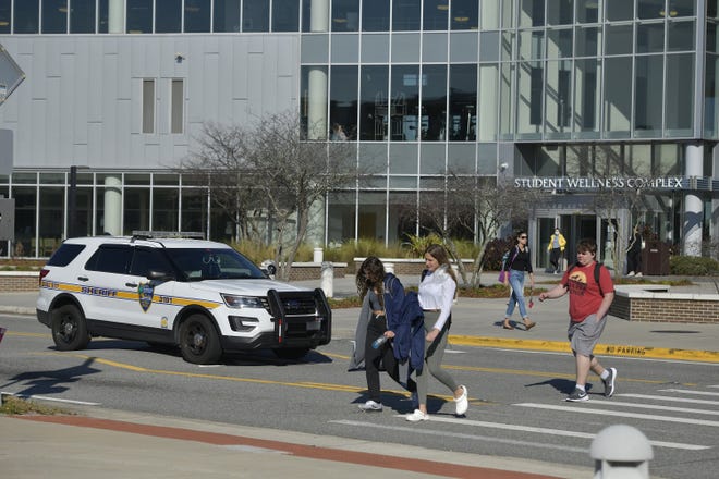 Students cross a road between buildings on the University of North Florida campus in this 2022 photo.