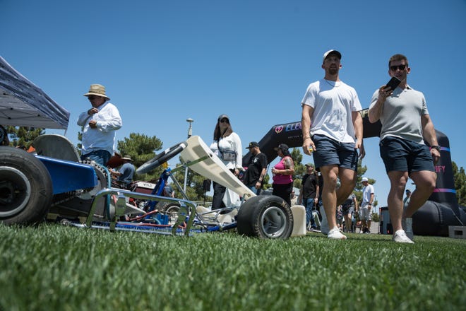 Visitors walk past a Mouser Electronics electric go kart at the Electrify Expo outside State Farm Stadium on May 4, 2024 in Glendale, Ariz.