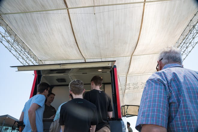 People gather around a model of the Lightship L1 electric travel trailer at the Electrify Expo outside State Farm Stadium on May 4, 2024 in Glendale, Ariz.