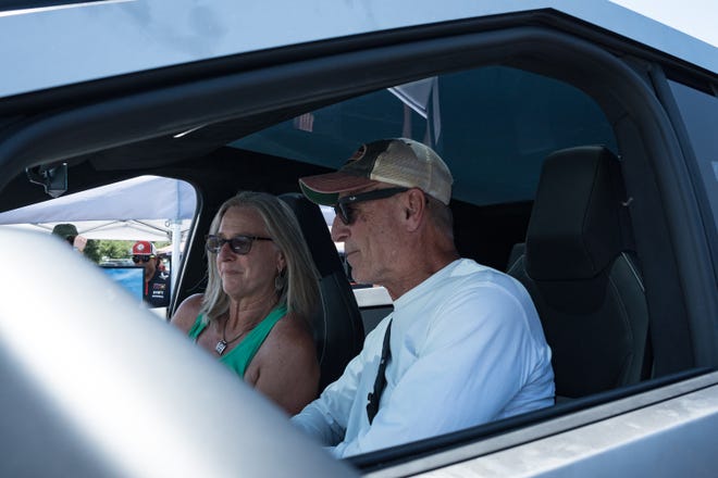 Kathy Konrad (left) and Michael Carneal take a look inside the Tesla Cybertruck at the Electrify Expo outside State Farm Stadium on May 4, 2024 in Glendale, Ariz. They have been on a waiting list for a different model of the Cybertruck for multiple years.