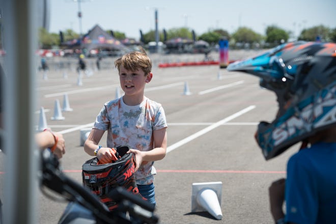 Levi Carmichael, 9, returns after a test ride on the Rawrr Mantis Mini electric bike for kids at the Electrify Expo outside State Farm Stadium on May 4, 2024 in Glendale, Ariz.